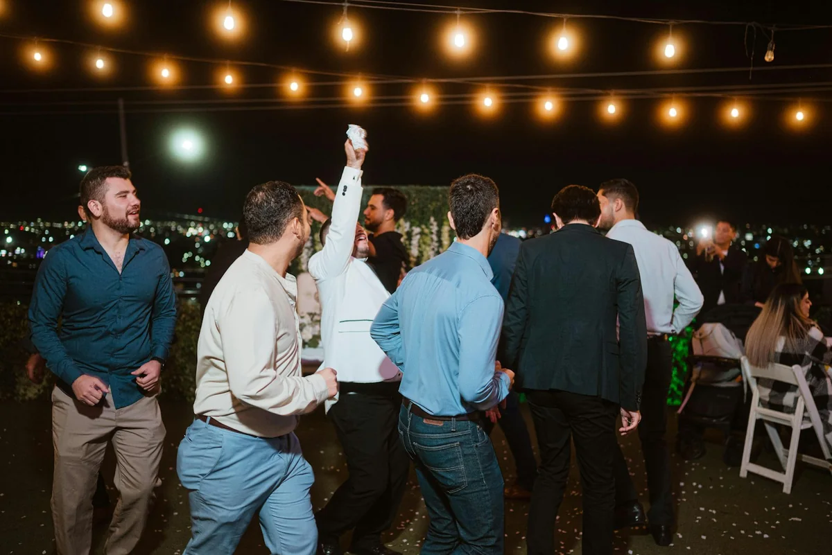 Guests dancing outdoors under string lights