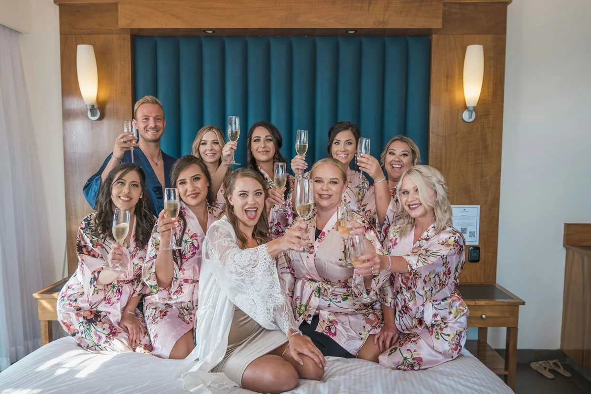 A bridal party raising glasses while getting ready